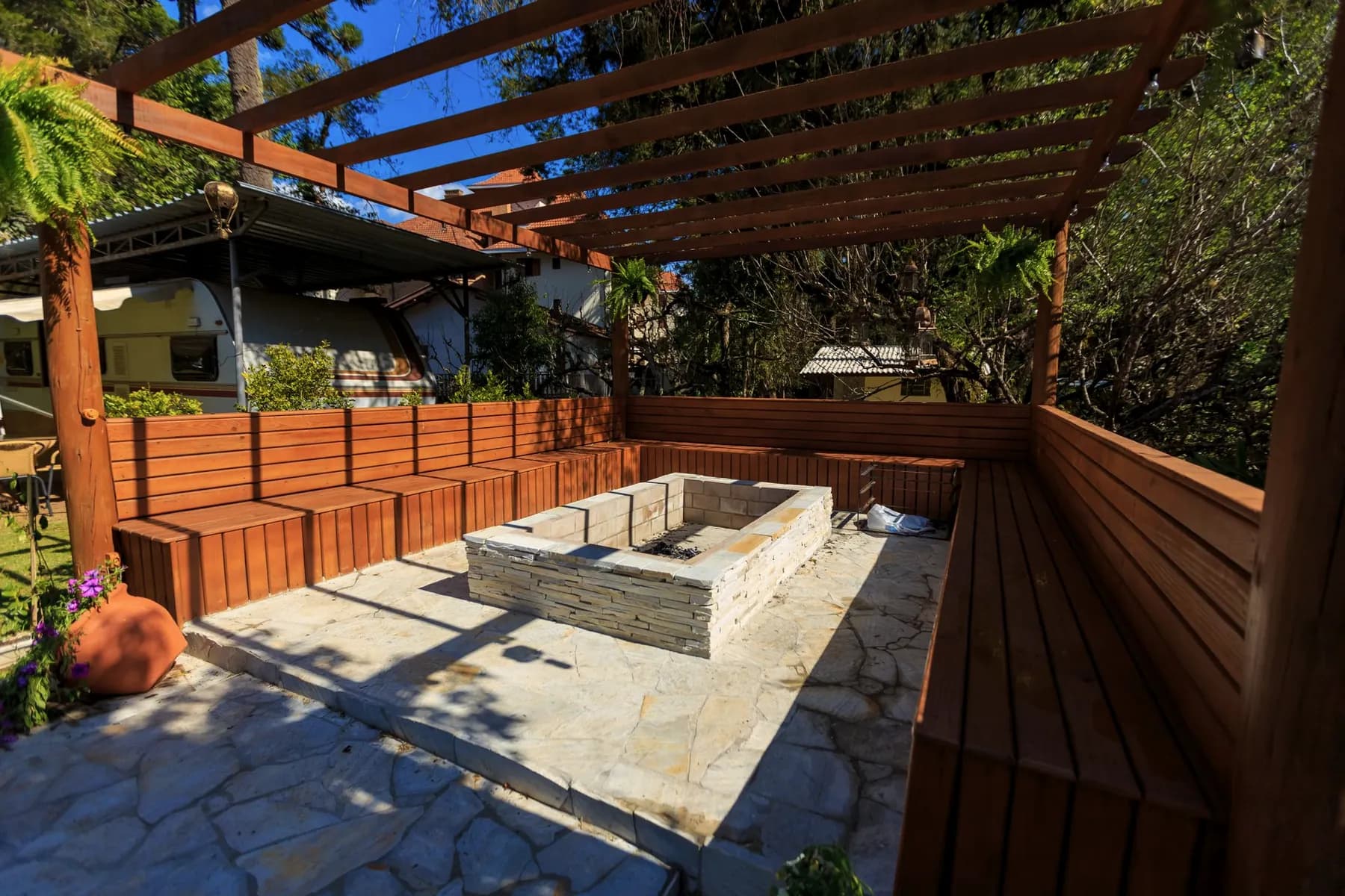 Outdoor living space with stone counter and pergola — Baltimore area, MD.