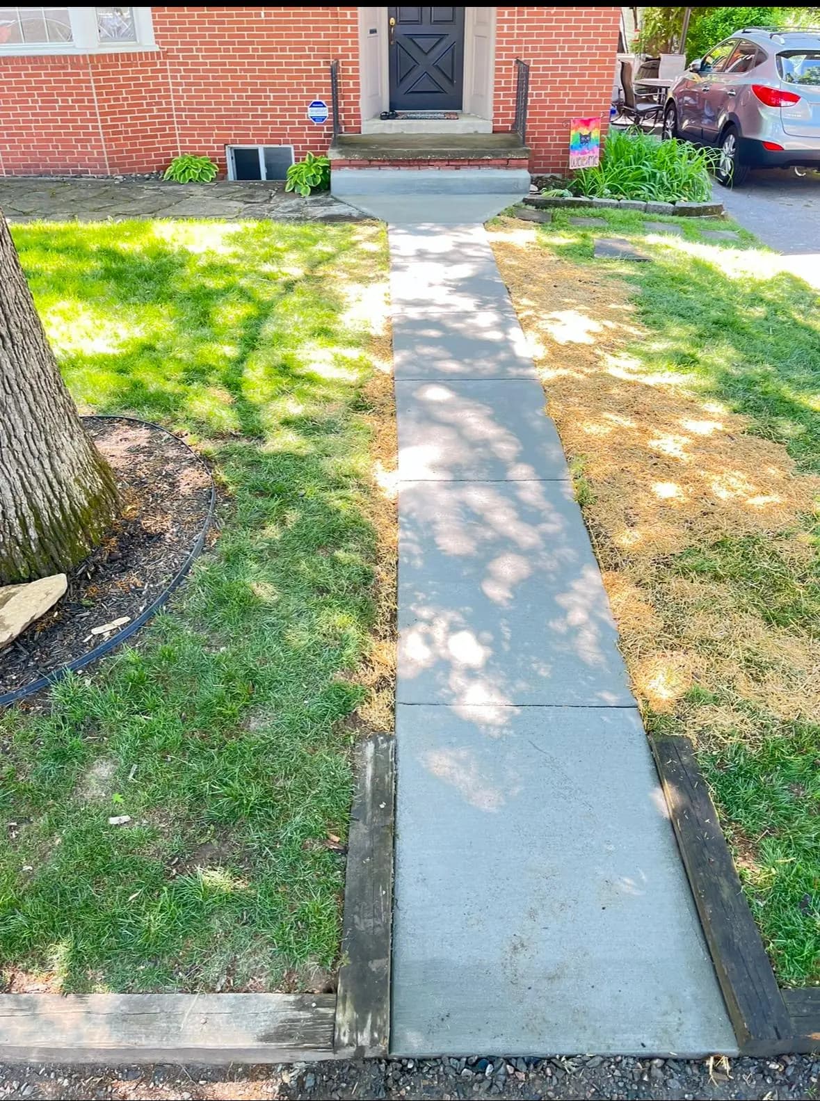 New concrete sidewalk with a clean broom finish alongside a lawn — Baltimore area, MD.