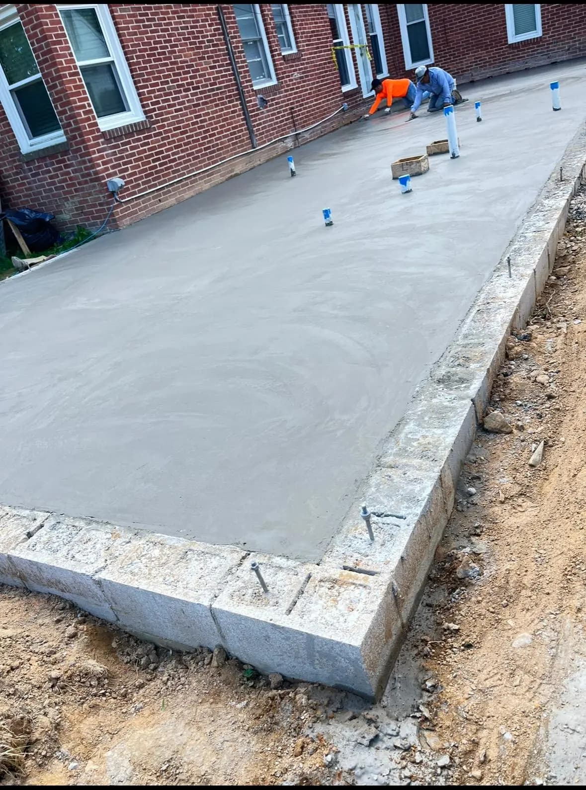 HJ Construction crew finishing a freshly poured concrete slab — Baltimore area, MD.