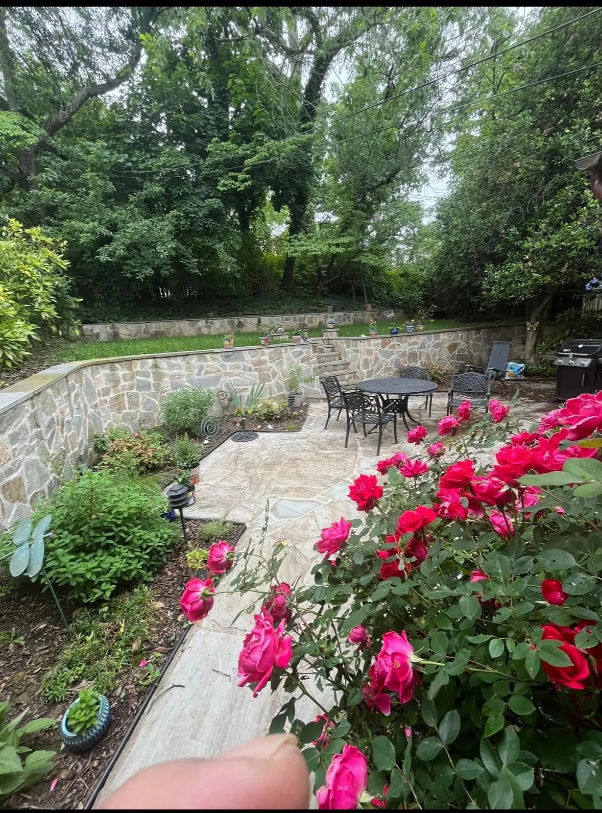 Tiered natural-stone retaining walls with a flagstone patio and garden — Baltimore area, MD.
