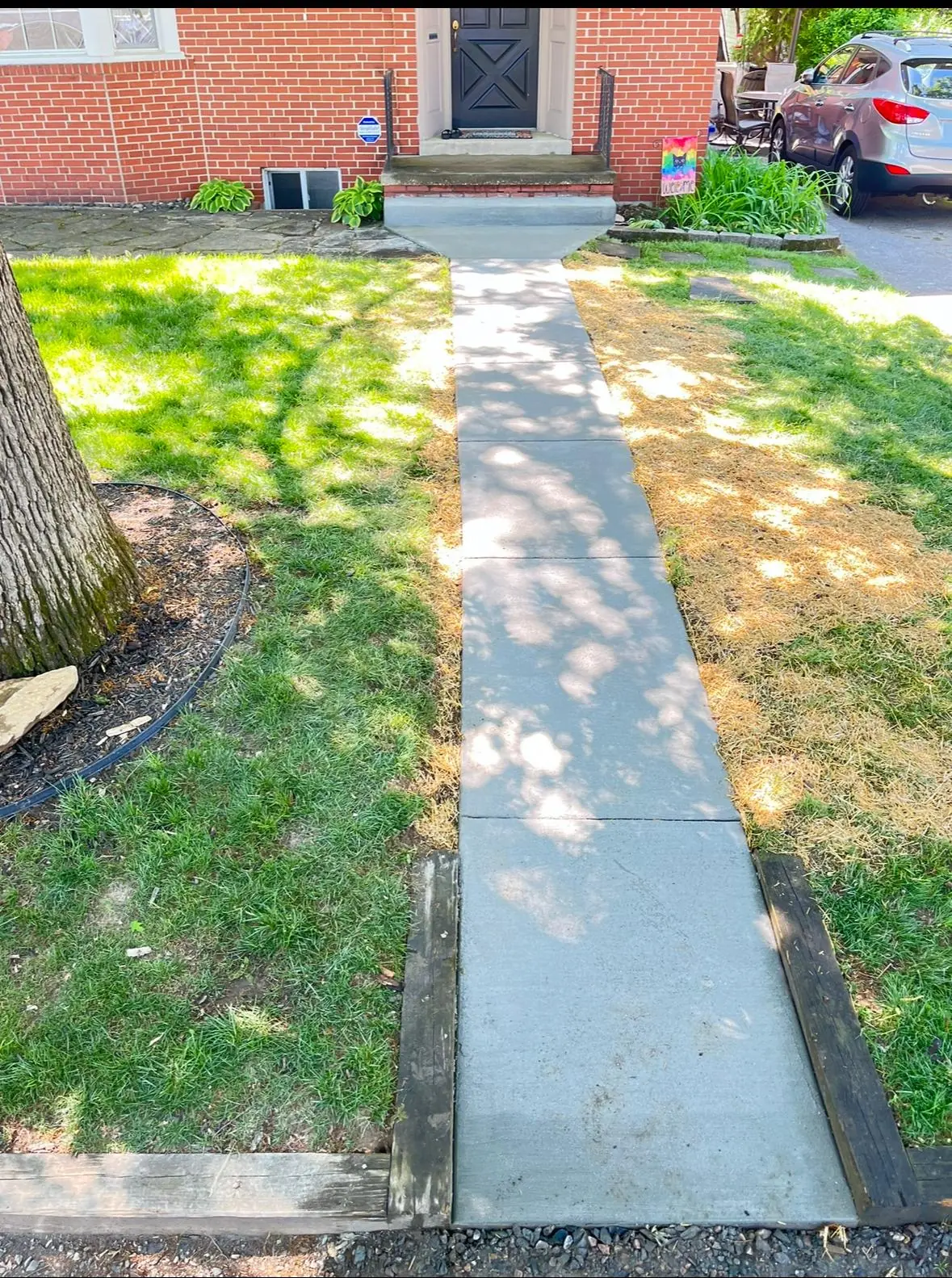 New concrete sidewalk with a clean broom finish alongside a lawn — Baltimore area, MD.